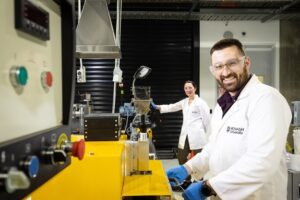 Edward Attenborough and Dr Leonie van 't Hag working in a laboratory at Monash University with scientific equipment used for creating bioplastics from food waste sugars.