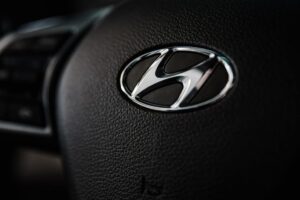 Close-up of Hyundai logo on a black steering wheel representing the 2027 Tucson Hybrid