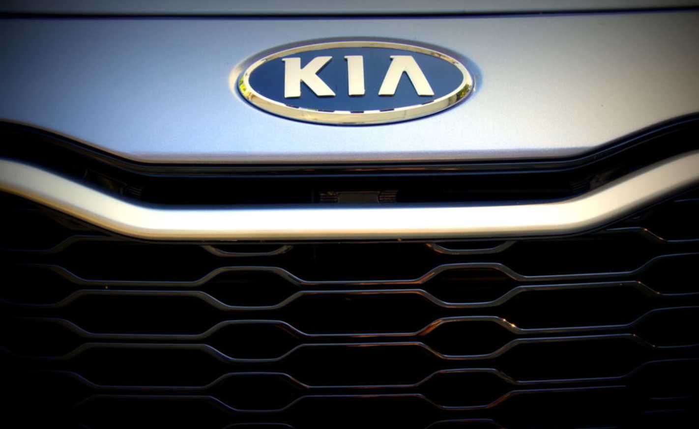 Kia emblem and front grille on a 2012 Kia Optima Hybrid showing the distinctive honeycomb pattern and oval Kia logo
