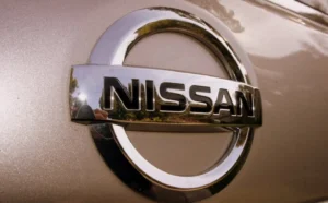 Nissan silver logo emblem on a vehicle with metallic finish background