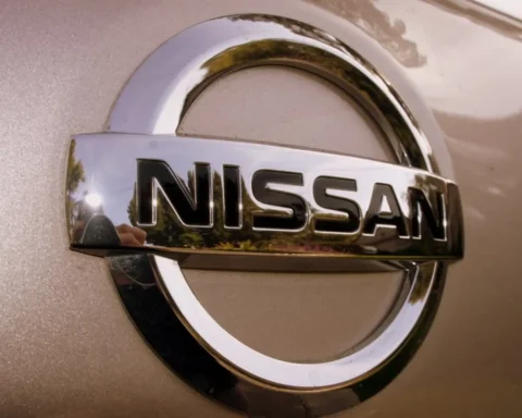 Nissan silver logo emblem on a vehicle with metallic finish background