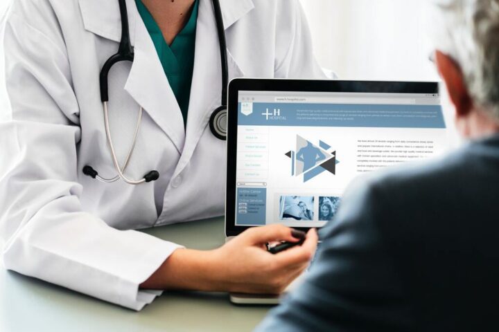 Medical professionals in discussion around a patient's bedside in a hospital setting, representing collaborative healthcare planning using patient personas.
