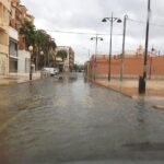 Rainy street in Puerto de Mazarrón, Murcia, Spain with shallow flooding and parked cars