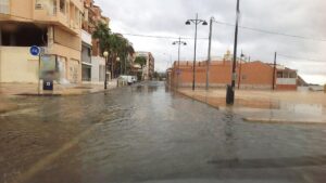 Rainy street in Puerto de Mazarrón, Murcia, Spain with shallow flooding and parked cars
