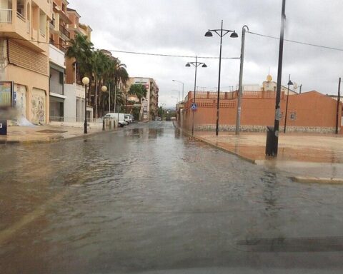 Rainy street in Puerto de Mazarrón, Murcia, Spain with shallow flooding and parked cars