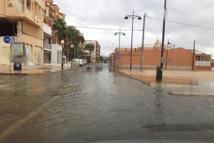 Rainy street in Puerto de Mazarrón, Murcia, Spain with shallow flooding and parked cars