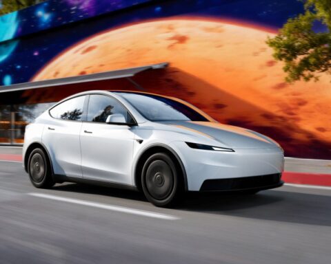 A white Tesla Model Y drives on a city street next to a colorful mural, with text overlay detailing features and pricing of the Model Y and Model 3 Standard models.