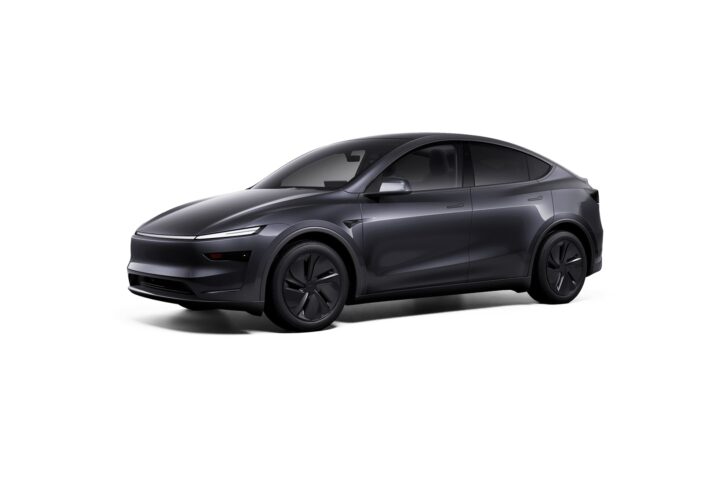 Front three-quarter view of a white Tesla Model Y Performance featuring redesigned bumpers, carbon fiber spoiler, and 21-inch Arachnid wheels against a plain white background.