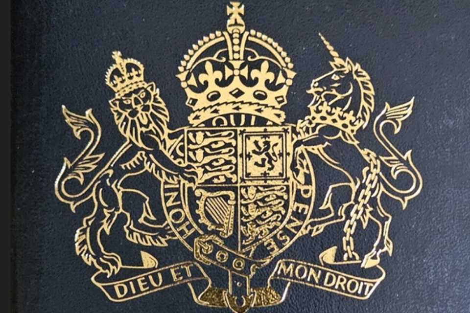 Updated dark‑blue UK passport showing His Majesty’s coat of arms in gold