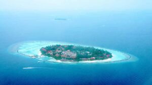 Aerial view of a Maldives resort island with overwater villas and a turquoise lagoon