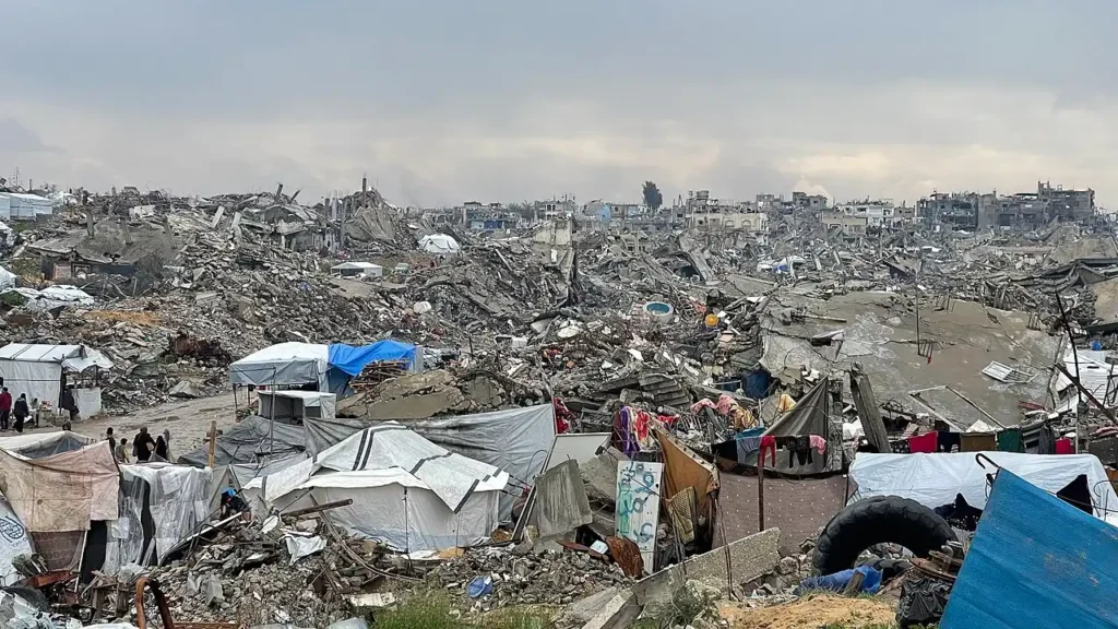 View of a heavily damaged street in central Gaza City showing collapsed façades and rubble-strewn pavement after February 2025 bombardment