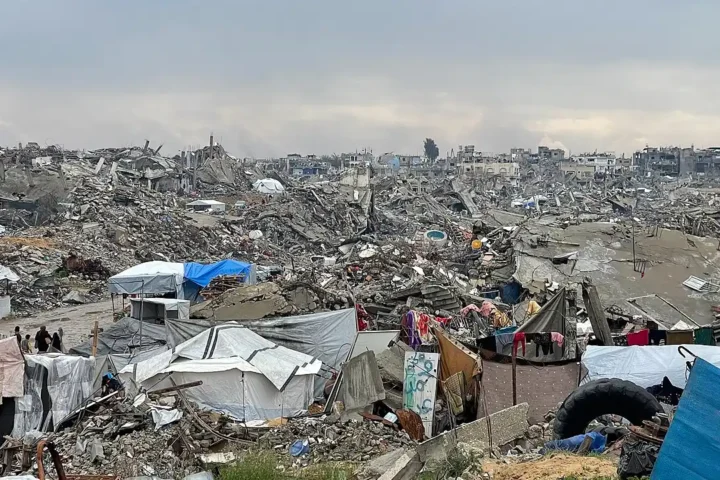 View of a heavily damaged street in central Gaza City showing collapsed façades and rubble-strewn pavement after February 2025 bombardment