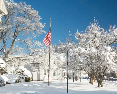 Commuters walking through New York Penn Station during a Thanksgiving travel rush, with directional signs overhead and travelers carrying luggage.