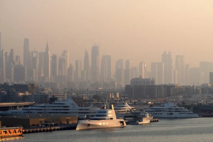 Cruise ships docked in Dubai with the skyline partially obscured by heavy haze caused by elevated air pollution.