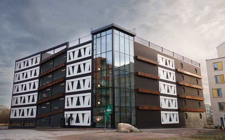 Exterior view of the Niels Bohr multi-storey car park in Brunnshög, Lund, featuring façade panels made from reused wind-turbine rotor blades.