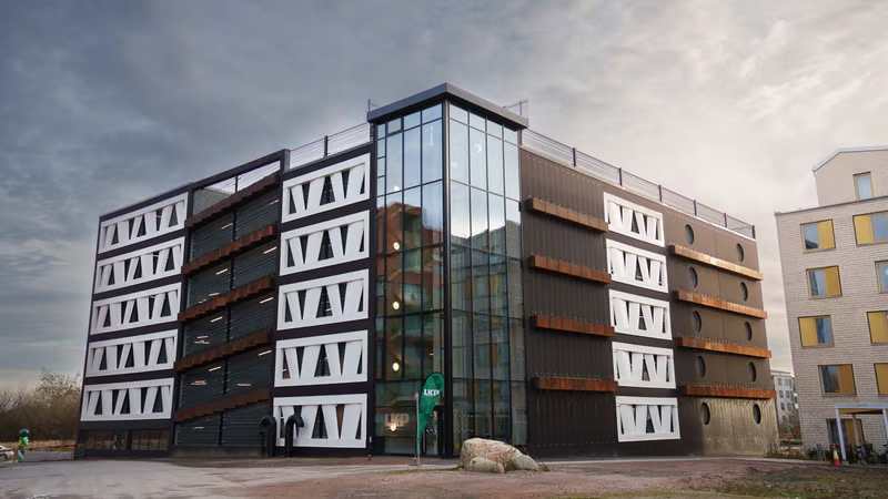 Exterior view of the Niels Bohr multi-storey car park in Brunnshög, Lund, featuring façade panels made from reused wind-turbine rotor blades.