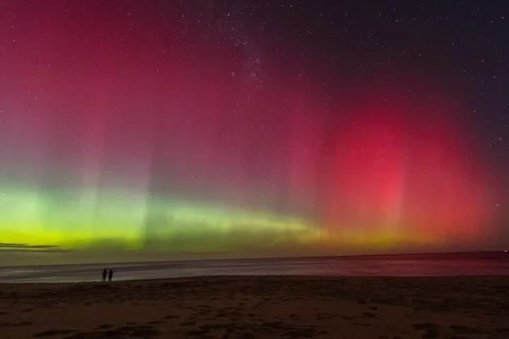 Aurora australis visible above Melbourne, Australia, during heightened geomagnetic activity caused by solar storms.
