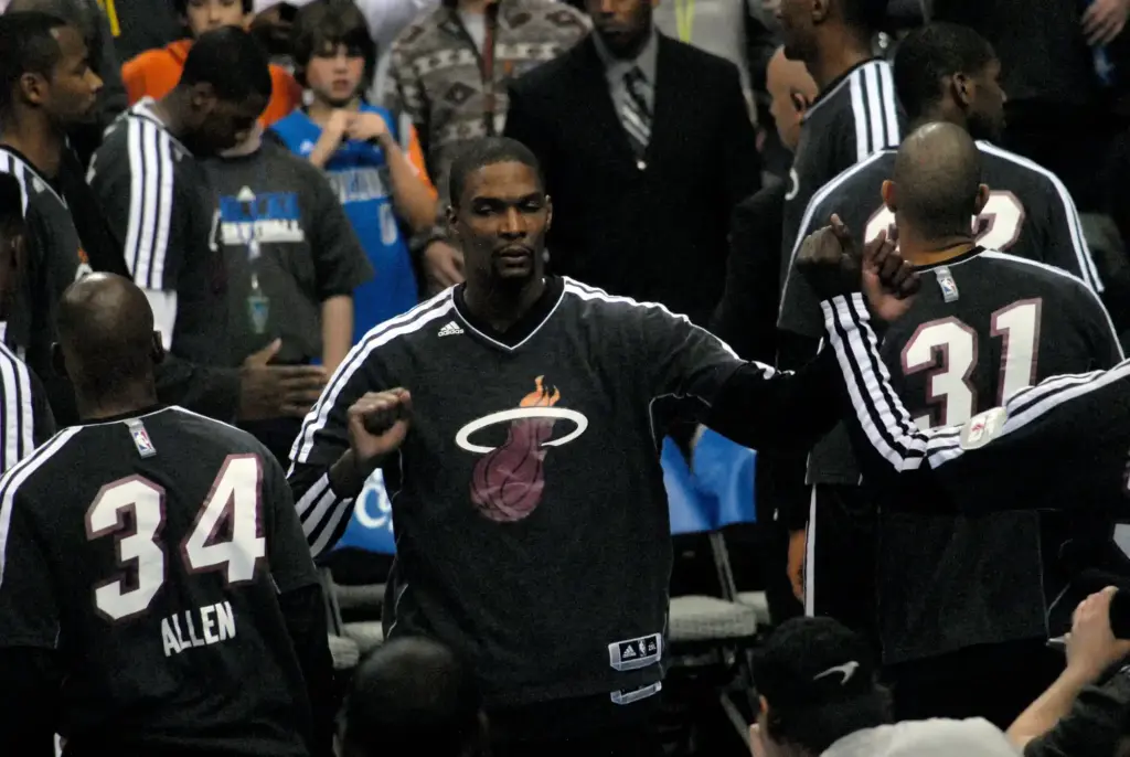 Chris Bosh in a Miami Heat warm-up suit fist-bumping teammates during pregame introductions in December 2012.