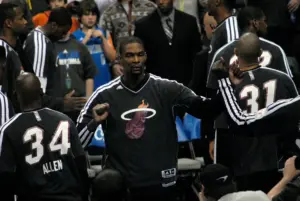 Chris Bosh in a Miami Heat warm-up suit fist-bumping teammates during pregame introductions in December 2012.