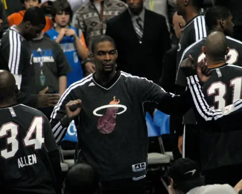 Chris Bosh in a Miami Heat warm-up suit fist-bumping teammates during pregame introductions in December 2012.