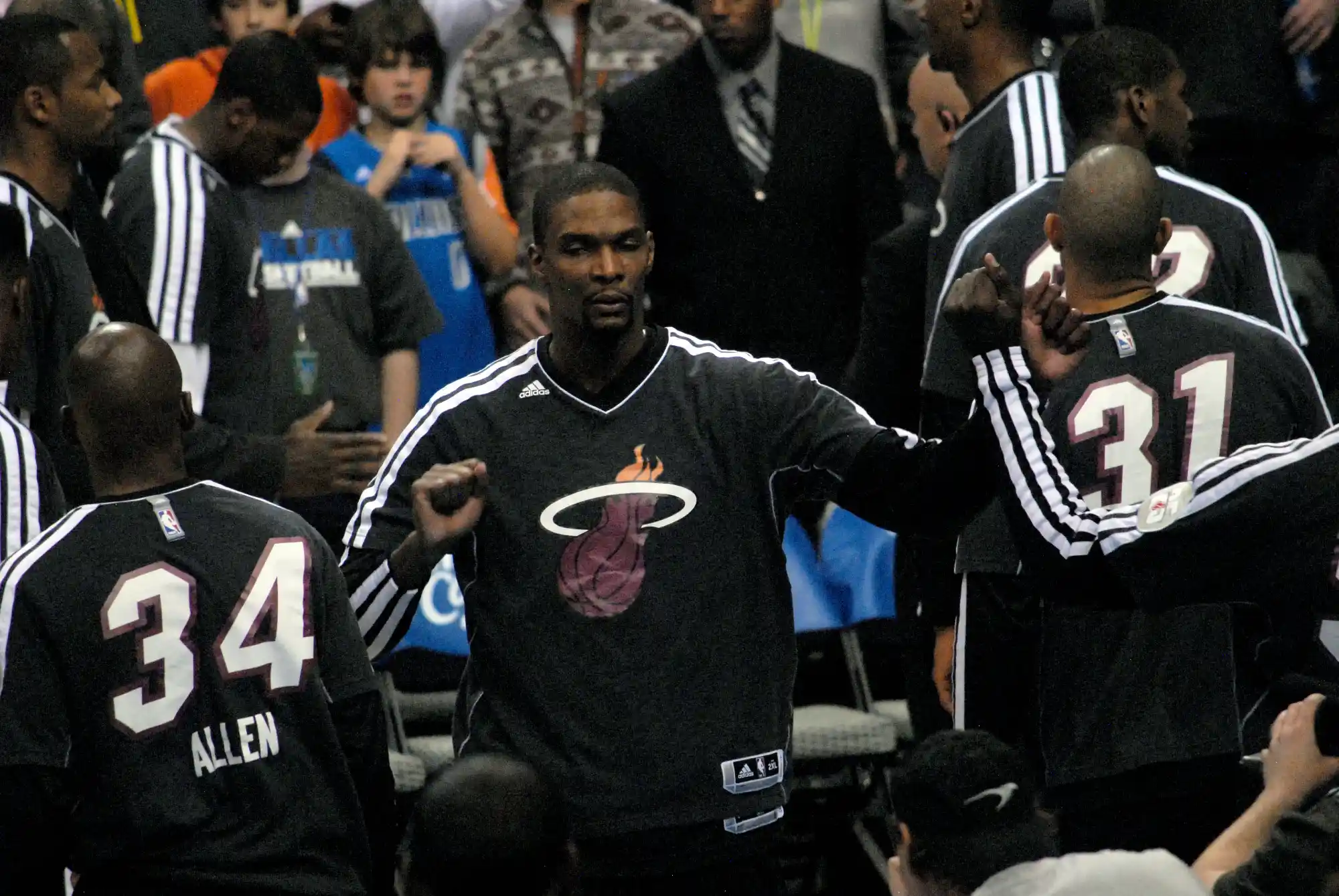 Chris Bosh in a Miami Heat warm-up suit fist-bumping teammates during pregame introductions in December 2012.