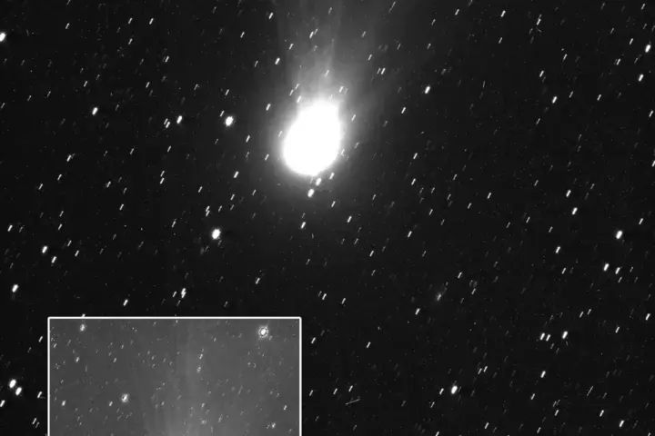 Image of interstellar comet 3I/ATLAS captured by ESA’s JUICE spacecraft JANUS camera on 6 November 2025 showing a bright coma, tail and jets, with arrows indicating the Sun’s direction and the comet’s velocity.
