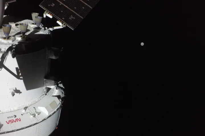 NASA Orion spacecraft with the Moon in the distance during Artemis II mission flight toward lunar flyby