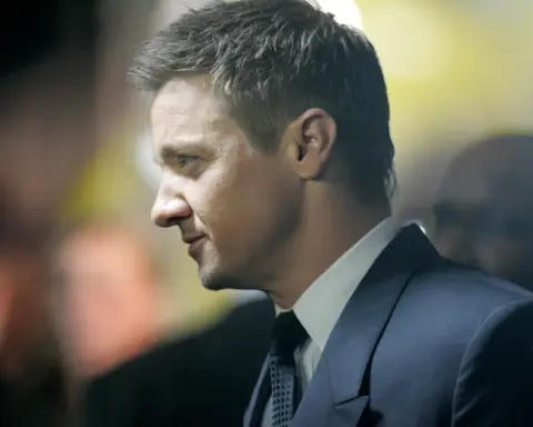 Jeremy Renner in profile at a red carpet event wearing a suit during The Bourne Legacy premiere in Sydney