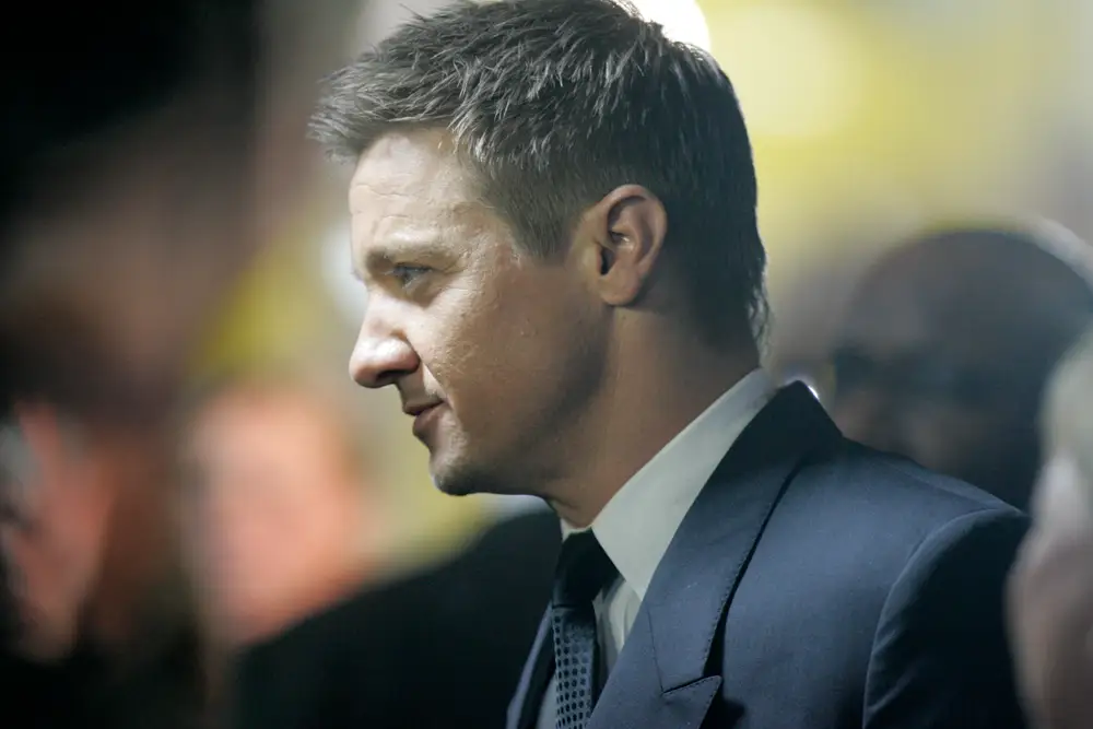 Jeremy Renner in profile at a red carpet event wearing a suit during The Bourne Legacy premiere in Sydney