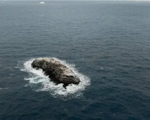 Ice-covered rocky island surrounded by ocean waves in the Weddell Sea, identified during the 2026 AWI Polarstern Antarctic expedition.