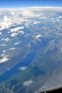 Aerial photograph of Lake McDonald and surrounding forested landscape in Glacier National Park, Montana, taken from above showing the remote wilderness terrain where bear encounters occur.