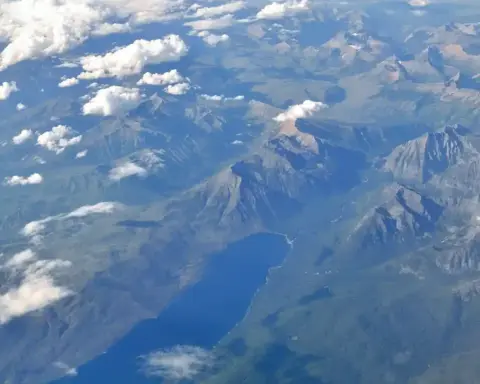 Aerial photograph of Lake McDonald and surrounding forested landscape in Glacier National Park, Montana, taken from above showing the remote wilderness terrain where bear encounters occur.