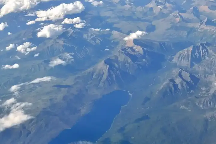Aerial photograph of Lake McDonald and surrounding forested landscape in Glacier National Park, Montana, taken from above showing the remote wilderness terrain where bear encounters occur.
