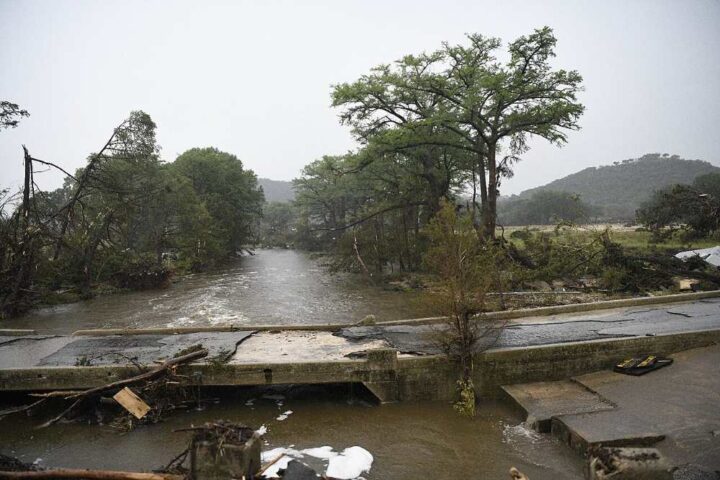 Floodwaters inundate a Texas community, with homes and vehicles partially submerged.