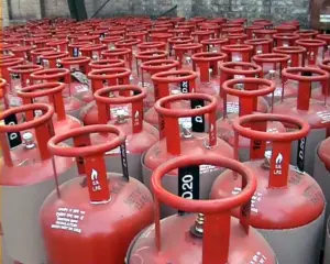 Red commercial LPG gas cylinders in storage, representing India's critical cooking fuel supply chain serving households and commercial establishments vulnerable to crude oil price volatility and geopolitical disruptions.