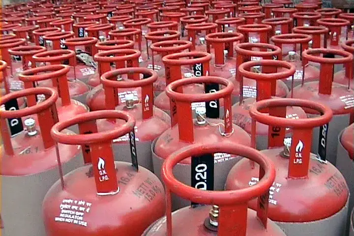 Red commercial LPG gas cylinders in storage, representing India's critical cooking fuel supply chain serving households and commercial establishments vulnerable to crude oil price volatility and geopolitical disruptions.