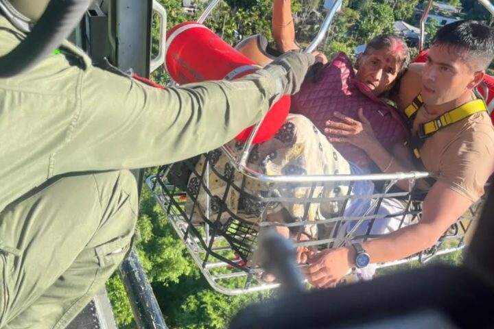 Indian Air Force personnel hoisting a flood-affected civilian from Brahmaputra valley terrain during July 2026 emergency rescue operations in Assam.