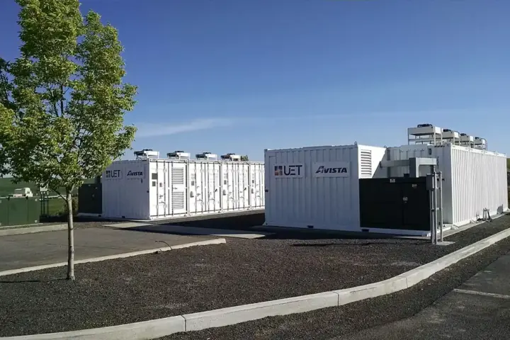 White containerised battery energy storage containers with UET and Avista branding, cooling units on roof.