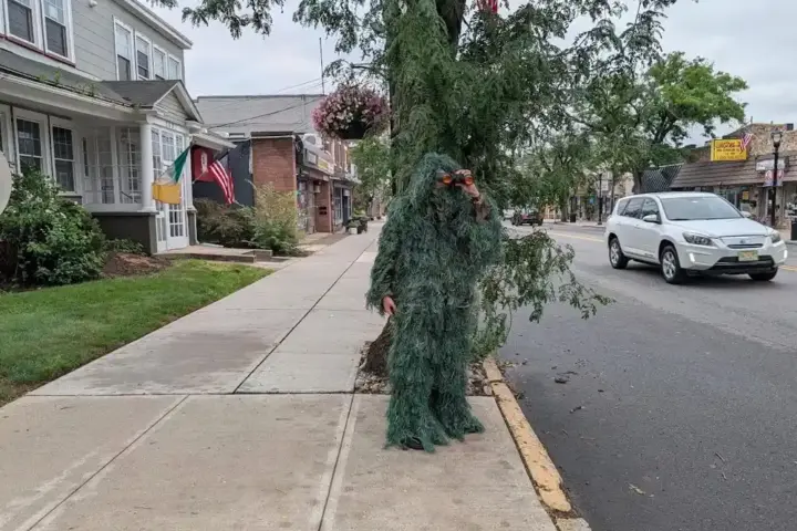 Police officer in camouflage disguise with binoculars.