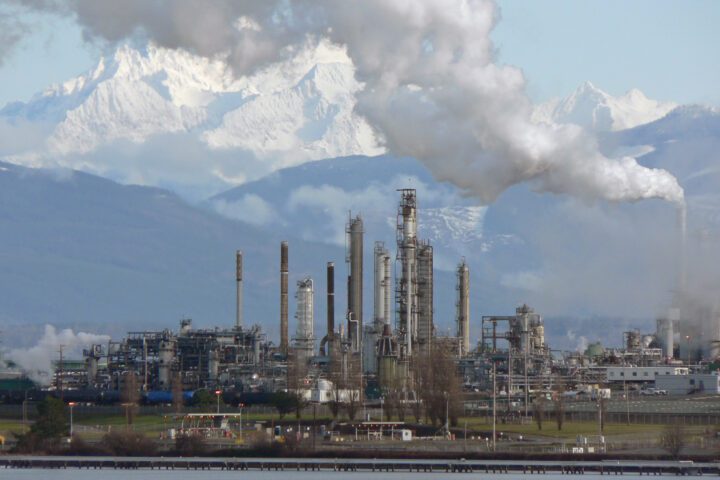 Aerial view of an oil refinery with distillation towers and storage tanks processing crude oil.