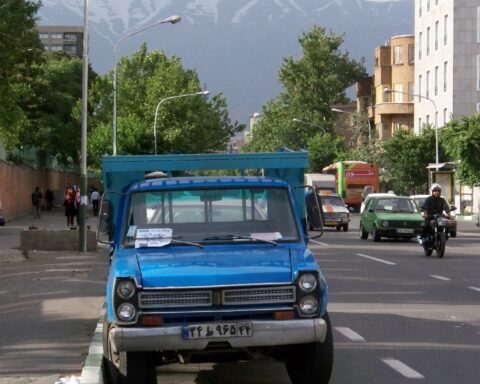 A city street in Tehran, Iran, with buildings and pedestrian activity.