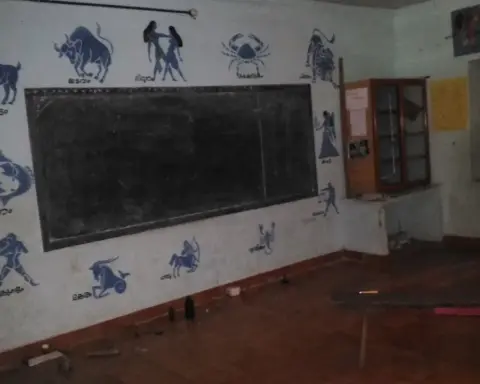Government primary school classroom with student desks and a blackboard in Kerala, India.