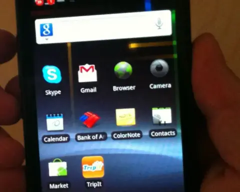 Google Nexus S smartphone held in a hand against a neutral background.