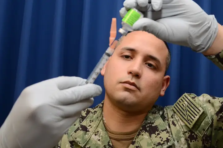 Healthcare worker preparing an influenza vaccination syringe.