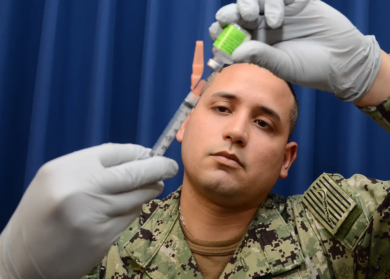 Healthcare worker preparing an influenza vaccination syringe.