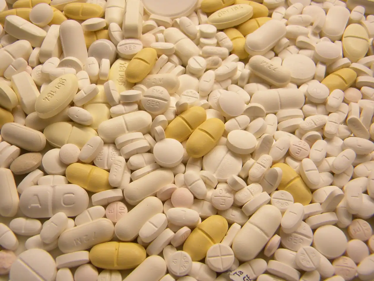 Photograph of a mix of pharmaceutical tablets and capsules, representing daily cardiovascular medication regimens.