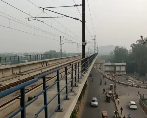 Elevated metro viaduct with safety railing at a Delhi Metro station in Noida