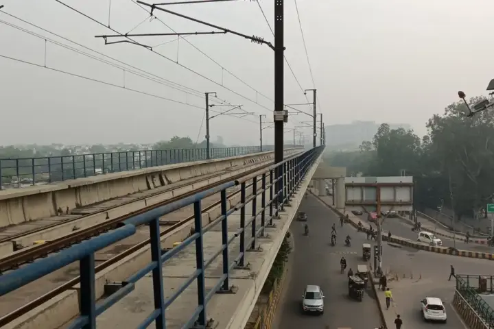 Elevated metro viaduct with safety railing at a Delhi Metro station in Noida
