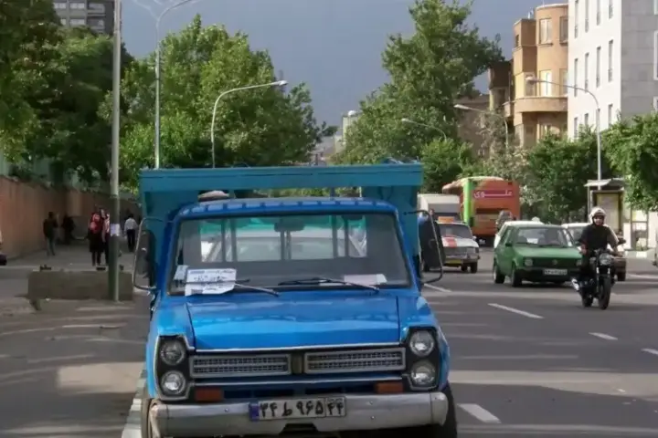 A city street in Tehran, Iran, with buildings and pedestrian activity.