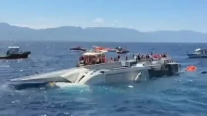 Capsized ferry in Mediterranean Sea with rescue vessels surrounding